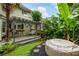 Landscaped backyard with wooden deck, pergola, swing, hot tub, and tropical plants, creating a relaxing outdoor oasis at 1450 Crescent Walk, Decatur, GA 30033