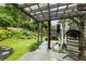 Expansive backyard with a covered deck, lush greenery, a tranquil seating area, and decorative windchimes at 1450 Crescent Walk, Decatur, GA 30033