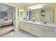 Bright bathroom with a double sink vanity and white cabinets, illuminated by modern lighting fixtures at 1450 Crescent Walk, Decatur, GA 30033