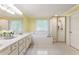 Bright bathroom with double sink vanity, framed mirror, separate walk-in shower and a soaking tub at 1450 Crescent Walk, Decatur, GA 30033