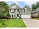 Charming home with a well-manicured lawn and a two-car garage, framed by mature trees and landscaping at 1450 Crescent Walk, Decatur, GA 30033