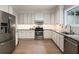 Bright kitchen featuring stainless steel appliances, granite countertops, and white cabinets at 1450 Crescent Walk, Decatur, GA 30033