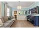 Elegant living room featuring a piano, a decorative mirror, and an open doorway to the kitchen at 1450 Crescent Walk, Decatur, GA 30033