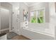 Bright bathroom features a soaking tub under a window and a glass-enclosed shower at 1797 Olive Se St, Atlanta, GA 30315