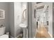 Stylish powder room with a pedestal sink, modern fixtures, and a view into the hallway at 1797 Olive Se St, Atlanta, GA 30315