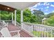 Second story porch with wooden flooring, chairs, white railings, and views of a lush green neighborhood at 1797 Olive Se St, Atlanta, GA 30315