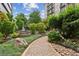 A lovely courtyard with stone fountain, winding walkway, and lush landscaping at 201 W Ponce De Leon Ave # 13, Decatur, GA 30030