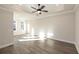 Spacious bedroom featuring a tray ceiling with fan and modern gray wood flooring at 205 Midnight Oak Run # 5, Alpharetta, GA 30009