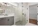 Bright bathroom featuring a glass shower with tile surround and gray vanity at 419 Southland Cir, Canton, GA 30115