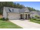 Home exterior featuring a brick-accented facade, gray roof, attached garage, and well-maintained lawn at 419 Southland Cir, Canton, GA 30115