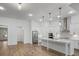 Bright, open kitchen with a large island, stainless steel appliances, white cabinets, hardwood floors, and modern lighting at 419 Southland Cir, Canton, GA 30115