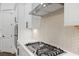 Close-up of a kitchen featuring a gas range, quartz countertops, modern backsplash, and stainless steel vent hood at 419 Southland Cir, Canton, GA 30115