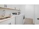 Well-lit laundry room with white cabinets, a utility sink, and modern washer and dryer units at 419 Southland Cir, Canton, GA 30115