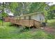 Ranch home featuring a spacious wooden deck in a lush, green backyard at 50 Woodland St, Buford, GA 30518