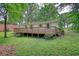 This ranch home has a large wooden deck and backyard with shade trees at 50 Woodland St, Buford, GA 30518