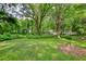 Picture of a spacious backyard featuring a verdant lawn and mature trees at 50 Woodland St, Buford, GA 30518