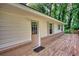 Charming single-story home with a wooden porch and white siding and beautiful landscaping at 50 Woodland St, Buford, GA 30518