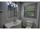 Bathroom with white vanity, lighting fixture, window, and commode at 50 Woodland St, Buford, GA 30518