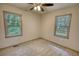 Neutral bedroom featuring a ceiling fan and two bright windows with green views at 50 Woodland St, Buford, GA 30518