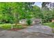 Charming single-story home with mature trees, spacious front yard and long driveway at 50 Woodland St, Buford, GA 30518