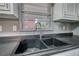 Close up of a kitchen sink in the kitchen with white cabinets, ample countertop space, and a window at 50 Woodland St, Buford, GA 30518