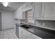 Bright kitchen featuring white cabinets and tile, a stainless steel sink, and a view of the exterior at 50 Woodland St, Buford, GA 30518