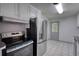 Kitchen features white tile floors, stainless steel appliances, and plenty of cabinet space for storage at 50 Woodland St, Buford, GA 30518