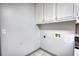 Bright laundry room with white cabinets for storage and tile floor at 50 Woodland St, Buford, GA 30518