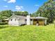 Spacious backyard showcasing the house with its brick foundation and a covered porch at 120 Ingleside Dr, Jonesboro, GA 30236