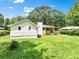Large backyard featuring the home with its brick foundation and covered porch at 120 Ingleside Dr, Jonesboro, GA 30236