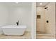 Bathroom featuring a soaking tub and glass enclosed tiled shower with modern fixtures at 120 Ingleside Dr, Jonesboro, GA 30236
