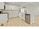 Modern kitchen featuring white cabinets, stainless steel appliances, island with sink, and light wood floors at 120 Ingleside Dr, Jonesboro, GA 30236