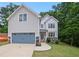 Charming two-story home with gray siding, stone accents, blue garage door, and a well-manicured front lawn at 2463 Whites Rdg, Decatur, GA 30034