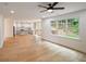 Open-concept living space showcasing kitchen, living room, hardwood floors, a ceiling fan, and large window to backyard at 2463 Whites Rdg, Decatur, GA 30034