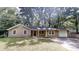 Charming single-story home with tan siding, mature trees, and a driveway at 5574 Oak Grove Dr, Acworth, GA 30102