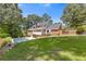 A spacious backyard featuring a swimming pool, a well-manicured lawn, and an attractive brick house at 828 Jami Ct, Lawrenceville, GA 30046