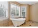 Bright bathroom featuring a soaking tub beneath shuttered windows with vintage fixtures at 828 Jami Ct, Lawrenceville, GA 30046