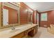 Retro bathroom featuring dual sinks, mirrors, and wallpaper decor with a warm and inviting atmosphere at 828 Jami Ct, Lawrenceville, GA 30046