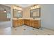Bathroom featuring double vanities with wooden cabinets, tile flooring and decorative mirrors at 828 Jami Ct, Lawrenceville, GA 30046