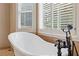Close-up of a clawfoot tub with vintage fixtures and shuttered windows at 828 Jami Ct, Lawrenceville, GA 30046