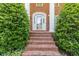 Close-up of a brick home's front entrance with a glass door, sconces, and a brick staircase at 828 Jami Ct, Lawrenceville, GA 30046