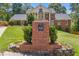 Elegant brick home with landscaped front yard and brick mailbox adorned with a decorative pineapple on a sunny day at 828 Jami Ct, Lawrenceville, GA 30046