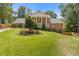 Charming two-story brick home with white columns, manicured lawn and colorful flowerbeds in a picturesque setting at 828 Jami Ct, Lawrenceville, GA 30046