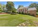 Spacious front yard with lush green grass and landscaping with a two-story brick home in the background at 828 Jami Ct, Lawrenceville, GA 30046