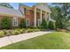 Landscaped front yard with lush green lawn and a brick home in the background with white columns at 828 Jami Ct, Lawrenceville, GA 30046