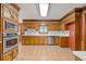 Traditional kitchen with warm wood cabinetry, tile backsplash, stainless steel appliances, and tile flooring at 828 Jami Ct, Lawrenceville, GA 30046