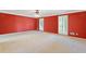 Spacious main bedroom with a large red wall, natural light and neutral carpet at 828 Jami Ct, Lawrenceville, GA 30046