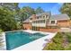 Backyard swimming pool with an extended patio area and a well-maintained brick house and lawn at 828 Jami Ct, Lawrenceville, GA 30046