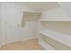 Attic closet with shelving and rod for hanging clothes with beige carpet at 828 Jami Ct, Lawrenceville, GA 30046