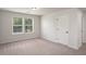 Carpeted bedroom with two windows for natural light, a closet, and a door to another room at 953 Mystic Way, Hampton, GA 30228